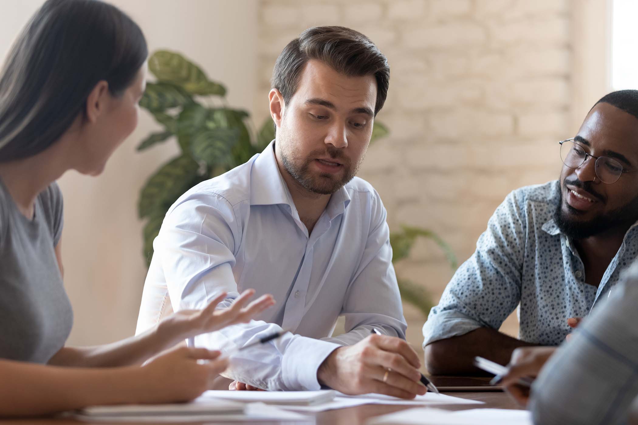 man-showing-two-colleagues-financial-statistics
